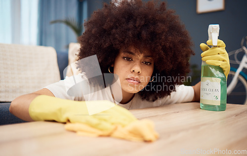 Image of Cleaning, housework and detergent with a black woman washing a table or wooden surface as a cleaner in a home. Housekeeping, maid and chores with a young female in a house to clean furniture