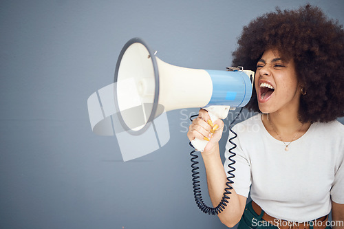 Image of Studio, megaphone and angry black woman shouting and protesting for change, freedom or democracy. Loudspeaker, bullhorn and speech of young female using voice, screaming in protest for justice.