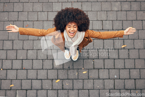 Image of Rain, happy and woman in city during winter standing outdoor in town with smile and joy. Happiness, freedom and excited girl from Mexico with an afro enjoying the drops of water outside in urban area