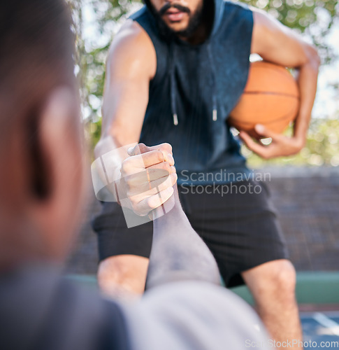 Image of Hands, basketball and help with a man athlete and rival playing a competitive game on a sports court. Team, exercise and assistance with a basketball player helping a friend during a match outside