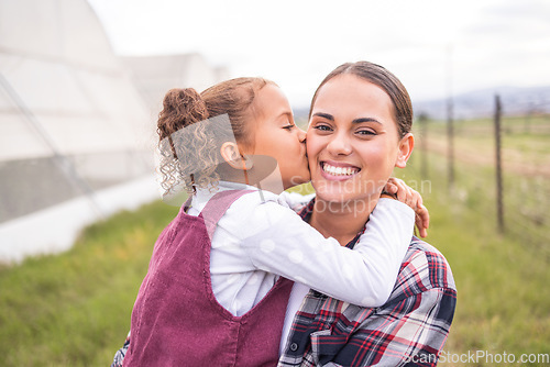 Image of Mother, kiss and girl on a sustainability, agriculture and ecology farm with family love and care. Portrait of a mama and kid on a eco friendly, clean energy and green farming countryside with smile