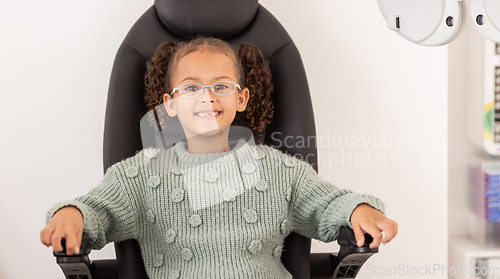 Image of Girl child, eye test glasses and smile in portrait at optometrist office, clinic or hospital for visual impairment. Young, female kid sitting or examination of eyes, sight and vision at optical exam