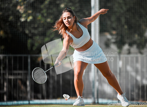 Image of Badminton, sports and woman athlete with a racket ready to swing in outdoor sport game. Young female player doing cardio exercise, match training and a wellness workout on a fitness court for health