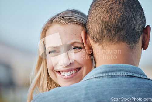 Image of Interracial couple, woman and smile on black man shoulder with happiness outdoor in summer for love. Happy, girl and man in diversity with hug, care and bonding in relationship in sunshine closeup