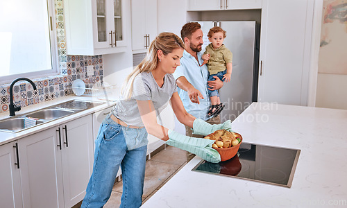 Image of Family, cooking and home kitchen with a mother, father and child waiting for dinner, food and a healthy meal. Man, woman and baby in house for bonding, eating and nutrition with roasted chicken