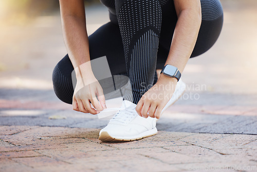 Image of Woman, hands and shoelaces tie for fitness, workout or training on city road, street or urban location. Zoom, runner or sports athlete running shoes on concrete ground for marathon or cardio exercise