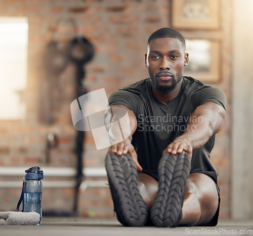 Image of Black man, stretching and fitness in gym workout, training and exercise with health goals, motivation or wellness target. Bodybuilder, sports athlete or personal trainer in warmup for muscle relief