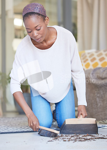 Image of Dust, woman and cleaning on a floor, sweeping and scoop in a living room for hygiene, wellness and healthy home space. Dirt, black woman and carpet clean for spring cleaning, clutter and tidy