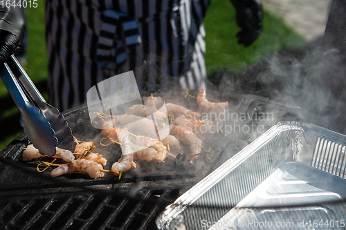 Image of A professional cook prepares shrimps