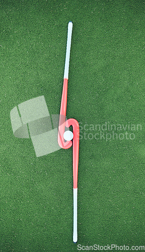 Image of Hockey, sticks and ball on turf grass at a stadium for a sports match, exercise or training. Fitness, workout and sport equipment on outdoor field for championship game, practice or skill development