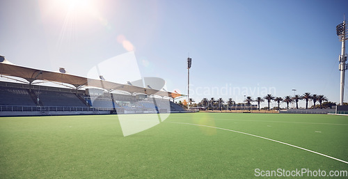 Image of Empty sport field, outdoor grass and training stadium ground in summer ready for sports. Lawn care, sunshine and blue sky by a exercise, workout and game venue isolated and remote for fitness