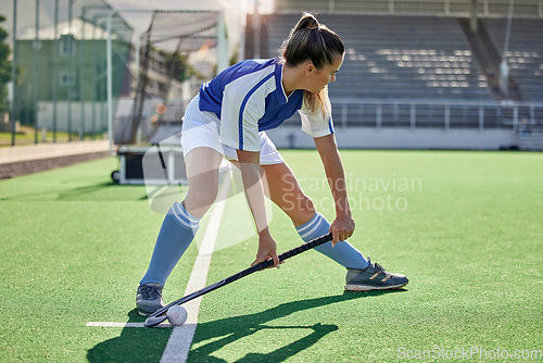 Image of Sports, hockey and woman in action on field with hockey stick ready to hit ball in game. Fitness, exercise and female athlete playing field hockey in outdoor stadium for workout, training and health