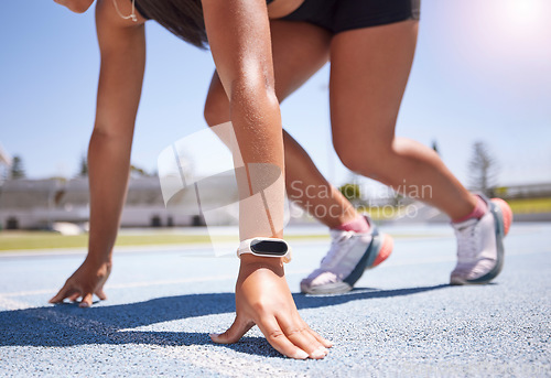 Image of Hands, race and runner with a sports woman on track ready to start an endurance or cardio workout for competitive training. Smartwatch, fitness and exercise with a female athlete running for sport