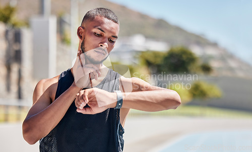 Image of Fitness, runner or black man checking pulse on smartwatch for training time, wellness goal or workout on tracker app. Athlete, jogger or man for watch progress, heart rate or health cardio in street