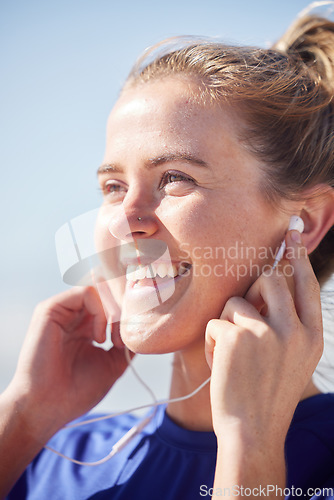 Image of Fitness, earphones and happy woman listening to music while doing an outdoor workout in Australia. Happiness, smile and girl training outside while streaming radio, audio or podcast for motivation.