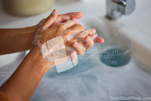 Image of Hand wash, cleaning and sink washing for healthcare, wellness and virus safety in a bathroom. Skin health, bacteria cleaner and soap with hands using liquid disinfection for corona prevention