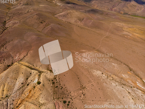 Image of Aerial shot of the textured yellow nad red mountains resembling the surface of Mars