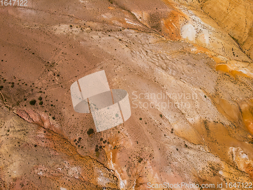 Image of Aerial shot of the textured yellow nad red mountains resembling the surface of Mars