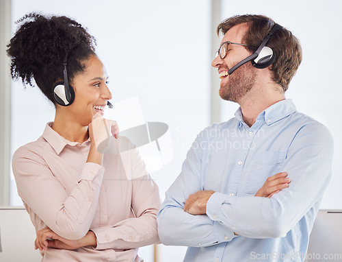 Image of Call center, man and woman with headset have conversation, talking and discussion with smile, happy and in office. Customer service, client support and diversity with agents, speaking and laughing.