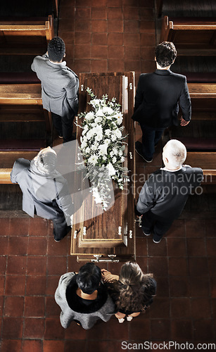 Image of Funeral, coffin and family mourning death of loved one, death and carrying wood casket in church for faith wake, eulogy and memorial. Pallbearers, spiritual grief and sad friends burial flower wreath