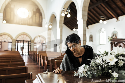 Image of Widow, coffin and sad at a funeral feeling depression from death sitting in a church. Depressed Indian woman with mourning, grief and mental health problem at an emotional religion burial event