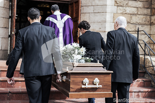 Image of Death, funeral and holding coffin in church for grief, bereavement and with family together on steps. Grieving, sad and congregation in mourning, sad and with goodbye before burial and wood casket.