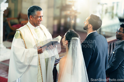 Image of Wedding, couple and priest with a bible in church praying to God with a Christian pastor reading the holy book. Love, bride and groom say an oath for a faithful and spiritual marriage commitment