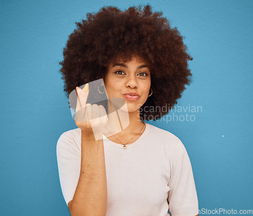 Image of Hand, korean symbol and portrait of happy woman with an afro from Puerto Rico in the studio. Happiness, care and girl model doing kpop i love you gesture from Korea while isolated by blue background.