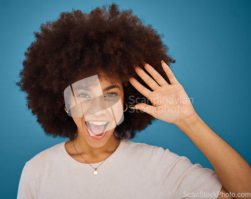 Image of Brazilian woman, afro or surprise face on blue background in studio in waving, hi or greeting hand gesture. Portrait, smile or happy model and excited or comic facial expression and fashion hairstyle