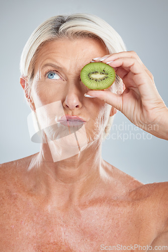 Image of Elderly woman, beauty cosmetic and eye care anti aging wellness treatment with fruit in studio. Mature model lips, natural fruit vitamins and facial collagen healthcare against grey background