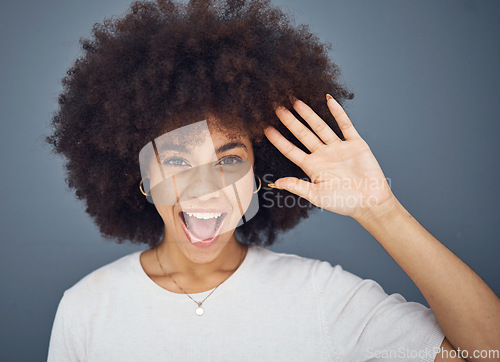 Image of Hand, wave and excitement with an afro black woman in studio on a gray background greeting with a smile. Portrait, hair and happy with an attractive young female waving to welcome or say hello