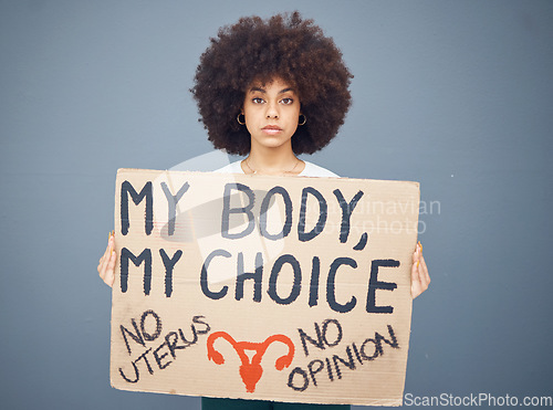 Image of Black woman afro, protest and poster for abortion, female choice or decision against a studio background. Portrait of African American female taking a stand holding cardboard sign for empowerment