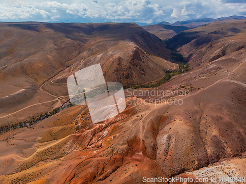 Image of Aerial shot of the textured yellow nad red mountains resembling the surface of Mars