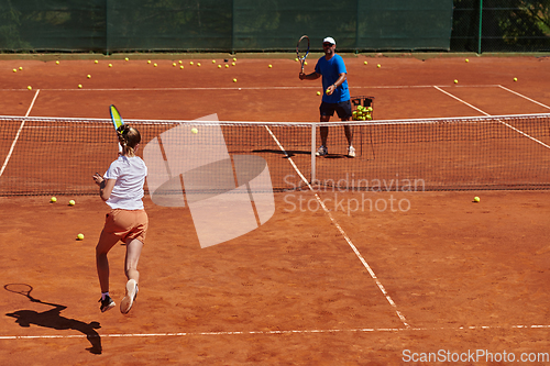 Image of A professional tennis player and her coach training on a sunny day at the tennis court. Training and preparation of a professional tennis player