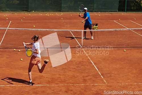 Image of A professional tennis player and her coach training on a sunny day at the tennis court. Training and preparation of a professional tennis player