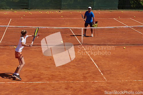 Image of A professional tennis player and her coach training on a sunny day at the tennis court. Training and preparation of a professional tennis player