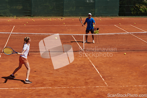 Image of A professional tennis player and her coach training on a sunny day at the tennis court. Training and preparation of a professional tennis player