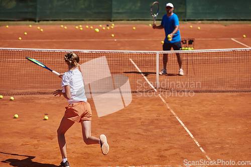 Image of A professional tennis player and her coach training on a sunny day at the tennis court. Training and preparation of a professional tennis player