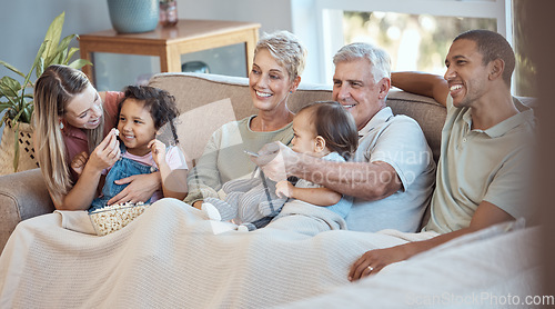 Image of Family, children and watching tv grandparents, parents and kids together on a sofa in the living room of their home. Movie, television and film with a man, woman and grandkids bonding over a video