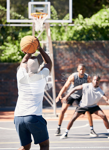 Image of Basketball, sports and athlete scoring during game or training on an outdoor court in the city. Score, goal and man playing, practicing or doing an exercise for championship match on basketball court