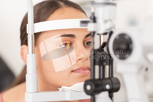 Image of Healthcare, eyes and woman eye test at a clinic for vision, health and eyesight on a slit lamp examination. Face, eye care and girl consulting optometrist for sight, wellness and glaucoma testing