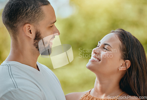 Image of Happy, smile and love with a young couple together outdoor in nature on a green background during summer. Park, romance and dating with an affectionate man and woman bonding on a sunny day in nature