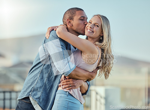 Image of Interracial man and woman, love and kiss outside feeling happy, in love and caring in the city. Romance, romantic and boyfriend and girlfriend embracing, hugging and kissing with affection in town
