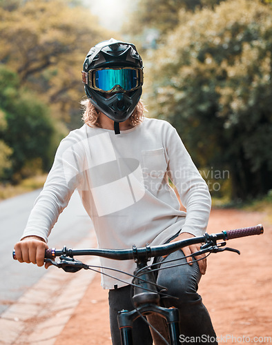 Image of Mountain bike, helmet and fitness with a man athlete sitting on his bicycle while outdoor in nature for a ride. Road, cycling and sport with a male rider training outside for exercise or workout