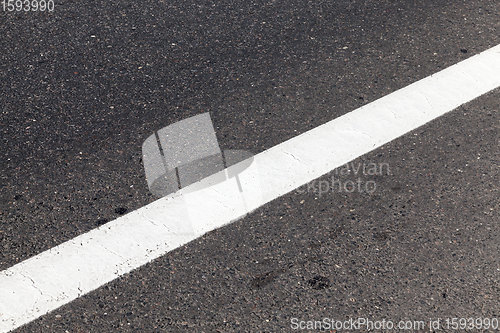 Image of close-up of an asphalt road with white road markings