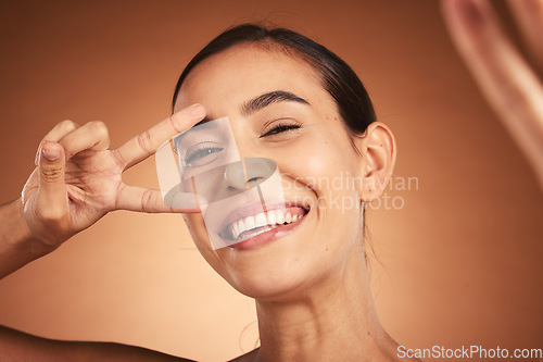 Image of Face, peace sign and woman happiness selfie of a model with a funny hand sign. Portrait of a comic hand gesture and beauty laughing, feeling silly and happy about youth with smile and beautiful skin