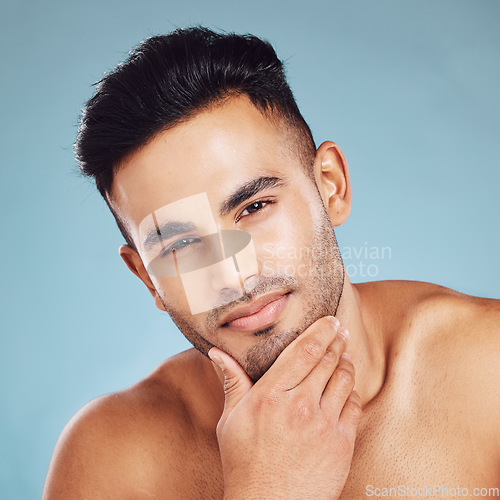 Image of Skincare, portrait and man with idea for beauty, wellness and health against a blue studio background. Thinking, cosmetic and young model with a facial beard and dermatology for cleaning of skin