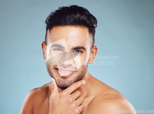 Image of Portrait, Indian man and skincare for wellness, smile and happy with blue studio background. Male, confident or natural beauty for cosmetics, luxury or happiness for organic facial or pride with fun