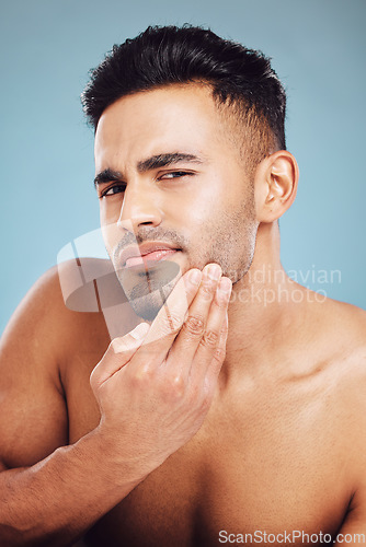 Image of Skincare, portrait and man in blue studio thinking of facial hair wellness, health and cosmetics beauty glow. Young, sexy and face model with beard growth idea for skin care, self love or dermatology