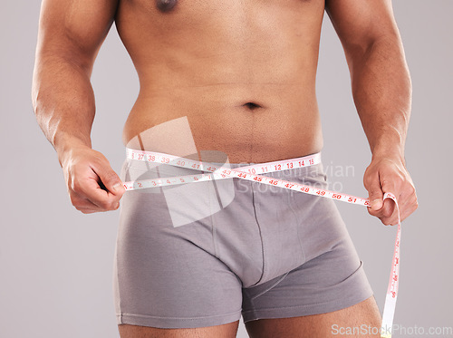 Image of Fitness, body and tape measure to lose weight from diet, exercise and sports training in studio for goals, motivation and inspiration. Model on grey background for weightloss progress and results